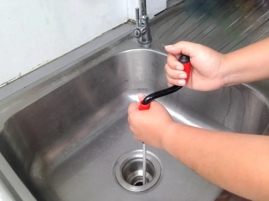 Drain Snaking Services in Downingtown, PA 1 A close shot of hands snaking a sink for cleaning