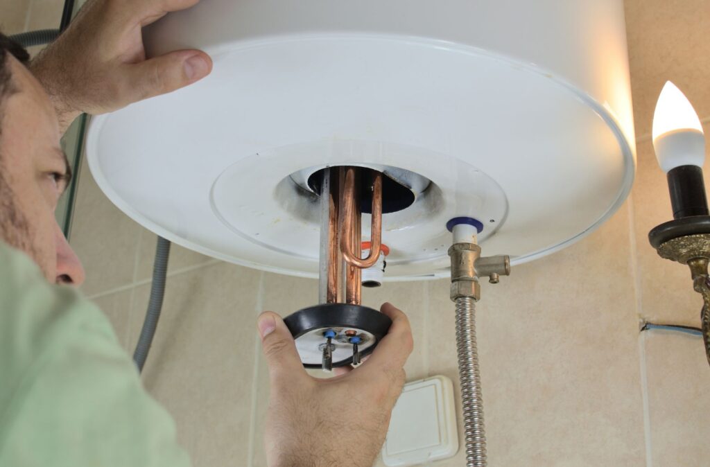 Hand working on water heater
