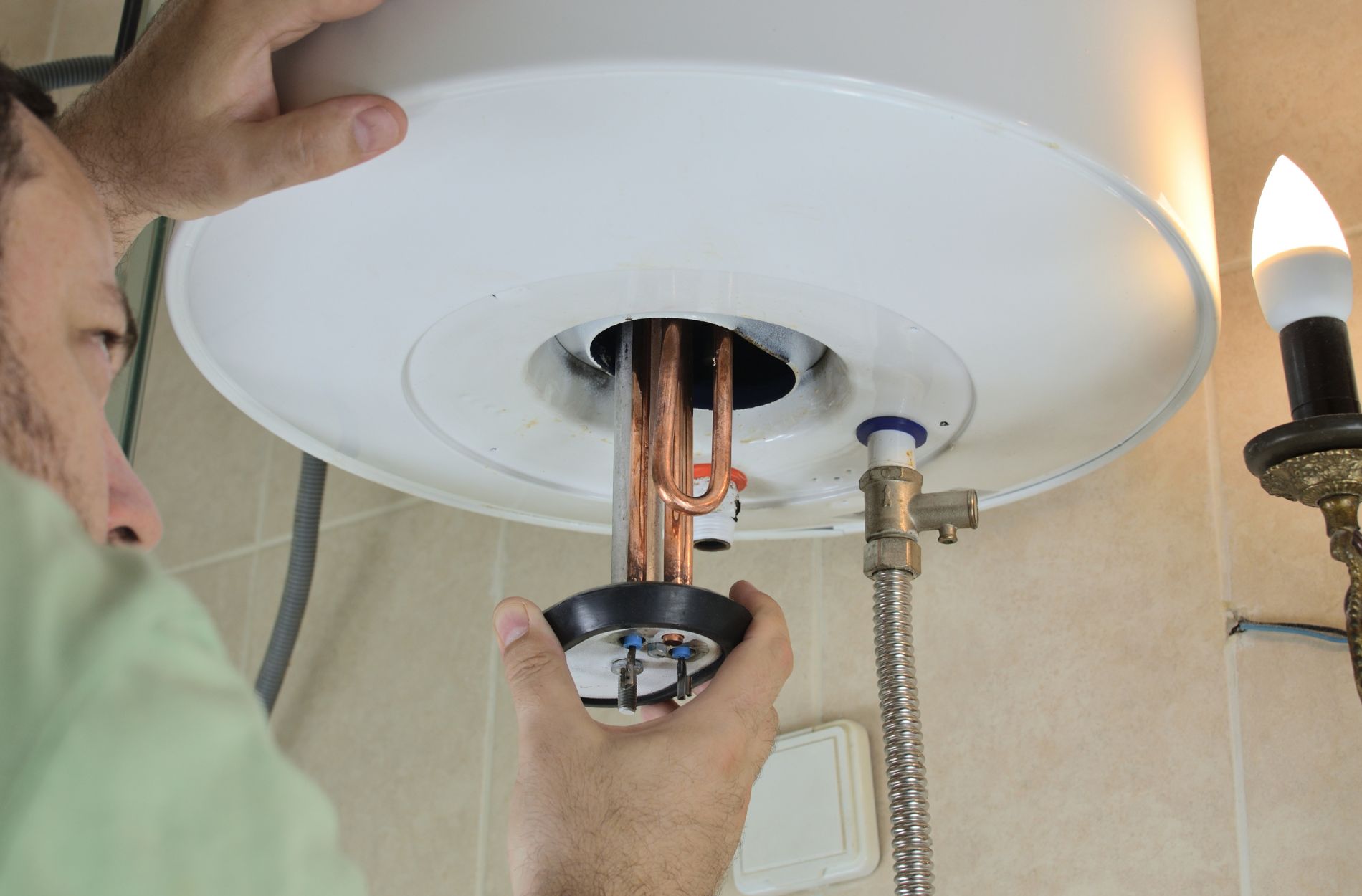 Hand working on water heater